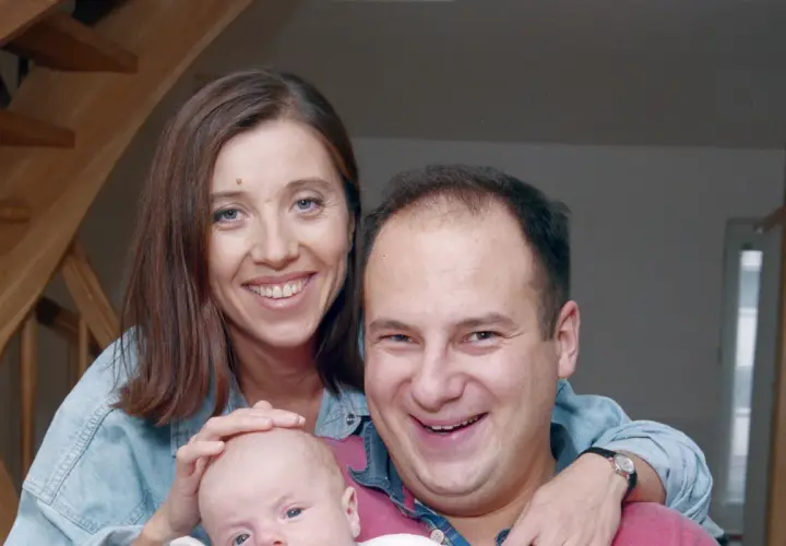 Szczęśliwi rodzice, Jakub i jego żona, trzymają na rękach swoje małe dzieci.
